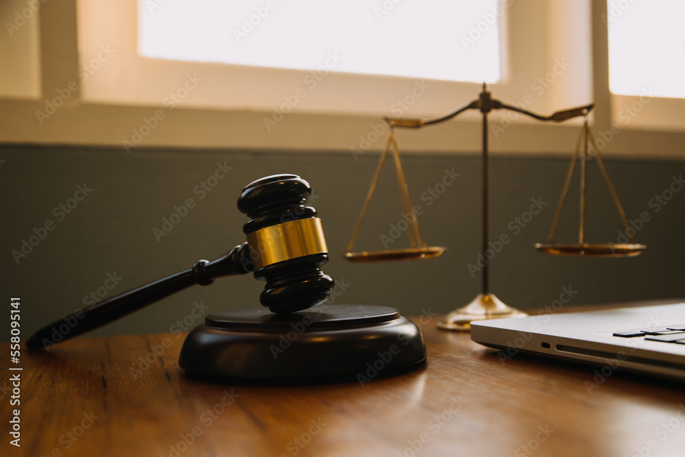 Business and lawyers discussing contract papers with brass scale on desk in office. Law, legal services, advice, justice and law concept picture with film grain effect Business and lawyers discussing contract papers with brass scale on desk in office. Law, legal services, advice, justice and law concept picture with film grain effect