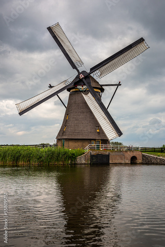 portrait of wind pump windmill at a canal at kinderdijk