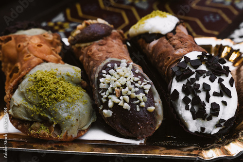 Cannoli. The typical Italian sweet. Filled with Pistachio, Chocolate and Ricotta.    photo