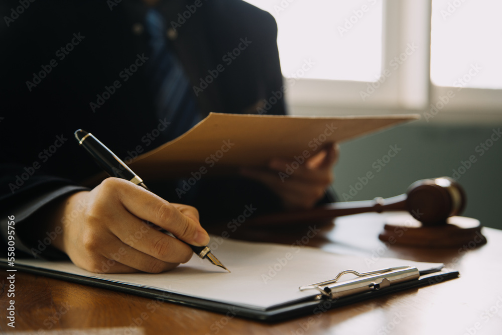 Business and lawyers discussing contract papers with brass scale on desk in office. Law, legal services, advice, justice and law concept picture with film grain effect Business and lawyers discussing contract papers with brass scale on desk in office. Law, legal services, advice, justice and law concept picture with film grain effect