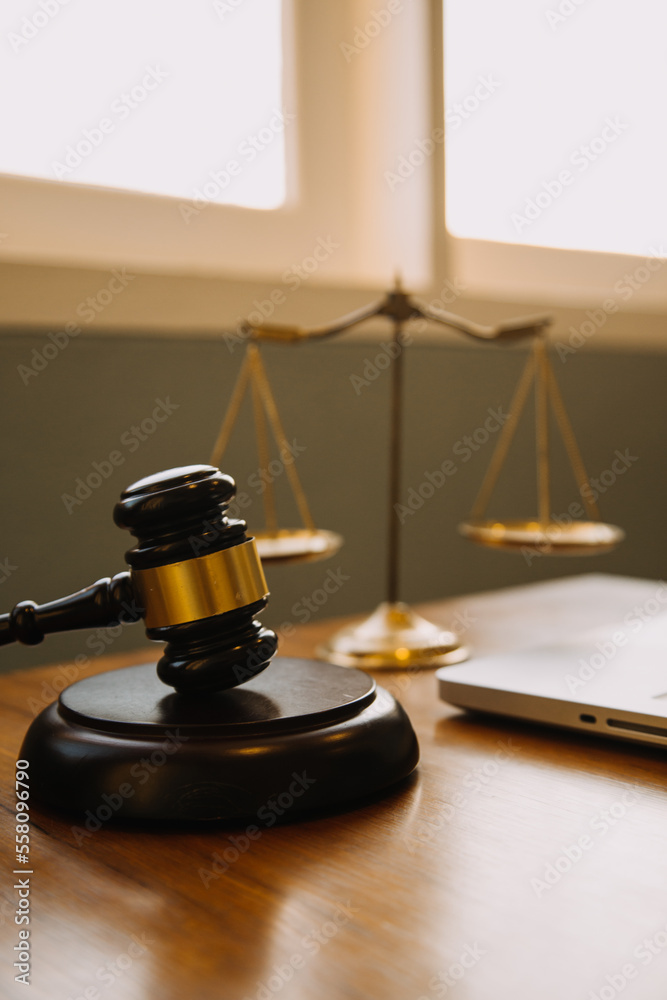 Business and lawyers discussing contract papers with brass scale on desk in office. Law, legal services, advice, justice and law concept picture with film grain effect Business and lawyers discussing contract papers with brass scale on desk in office. Law, legal services, advice, justice and law concept picture with film grain effect