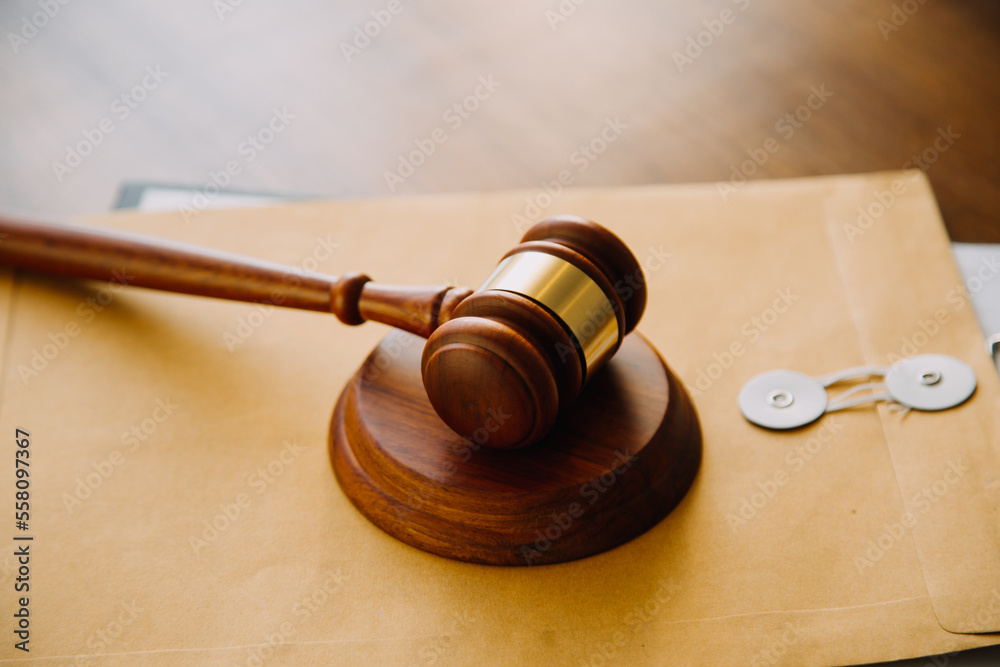 Business and lawyers discussing contract papers with brass scale on desk in office. Law, legal services, advice, justice and law concept picture with film grain effect Business and lawyers discussing contract papers with brass scale on desk in office. Law, legal services, advice, justice and law concept picture with film grain effect