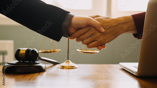 Business and lawyers discussing contract papers with brass scale on desk in office. Law, legal services, advice, justice and law concept picture with film grain effect