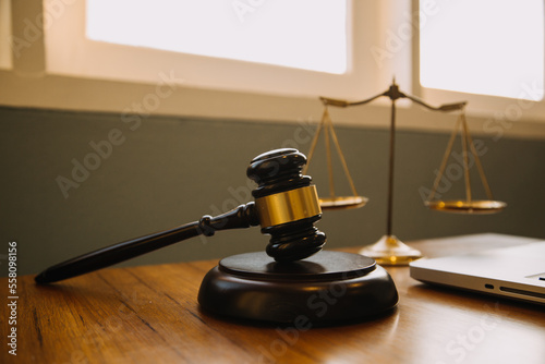 Business and lawyers discussing contract papers with brass scale on desk in office. Law, legal services, advice, justice and law concept picture with film grain effect