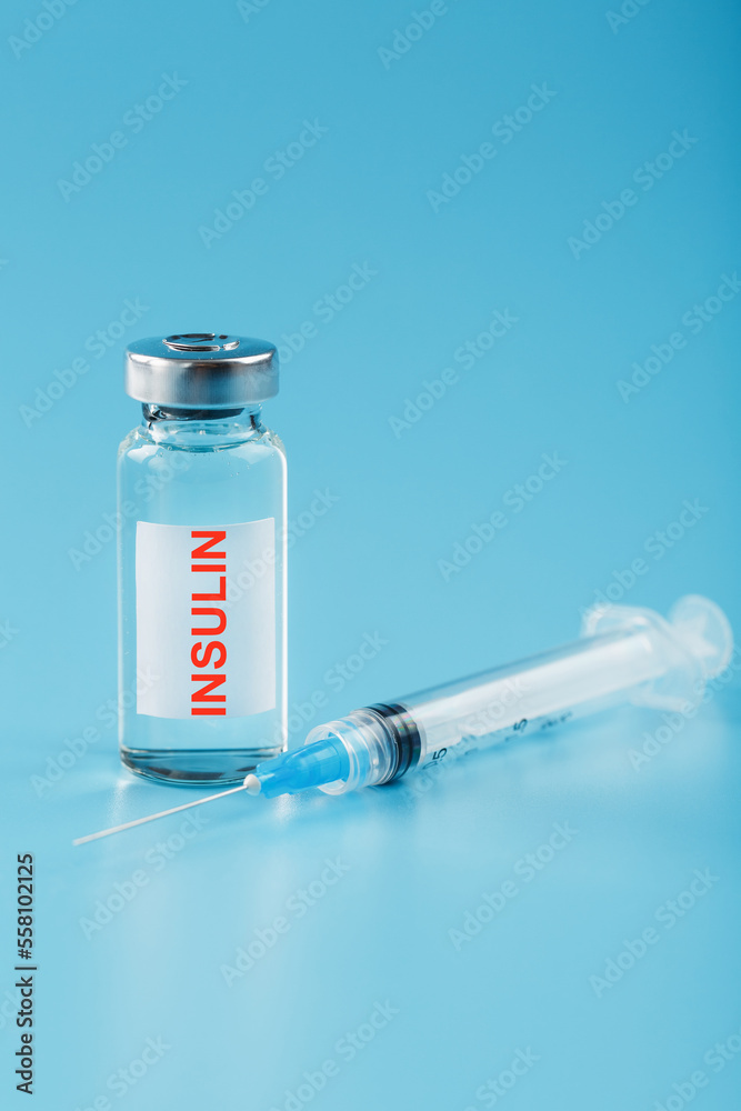 A bottle of insulin hormone and a syringe on the table A bottle of insulin hormone and a syringe on the table
