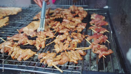 Grilling Thai sun-dried pork (Moo Dad Deaw) skewer for local street food vendor