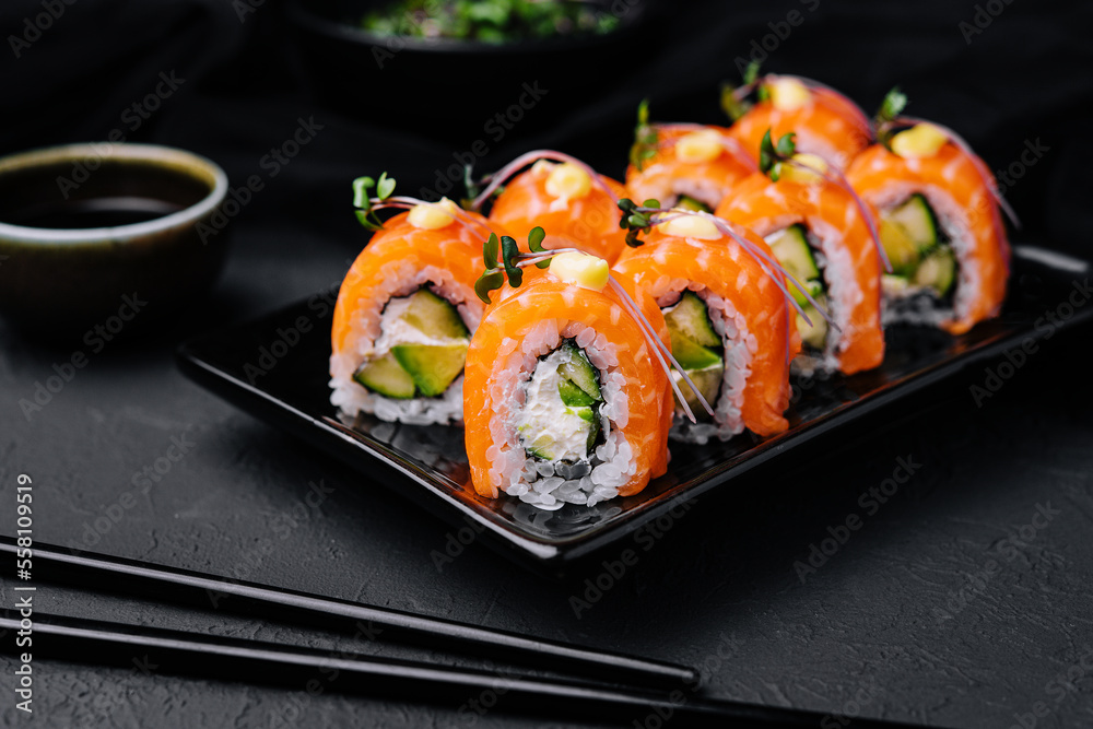 Philadelphia Sushi with avocado on black dish Philadelphia Sushi with avocado on black dish