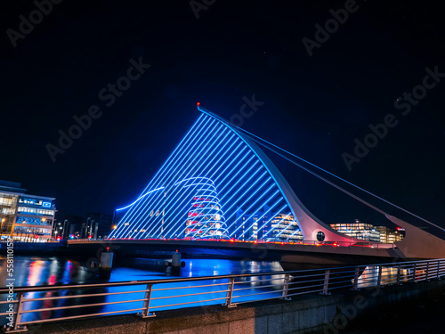 Illuminated in blue color and made in a shape of traditional Irish Harp Samuel Beckett Bridge in Dublin city, Ireland. Famous capital landmark. Night shot.