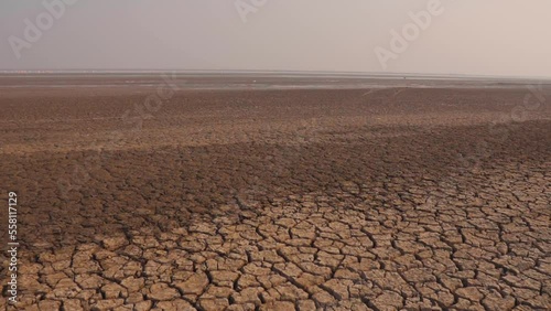Landscape view of dusty, drought land in summer season at Little Rann of Kutch, Gujarat, India. Climate change concept, global warming. Barren land of Kutch desert.
