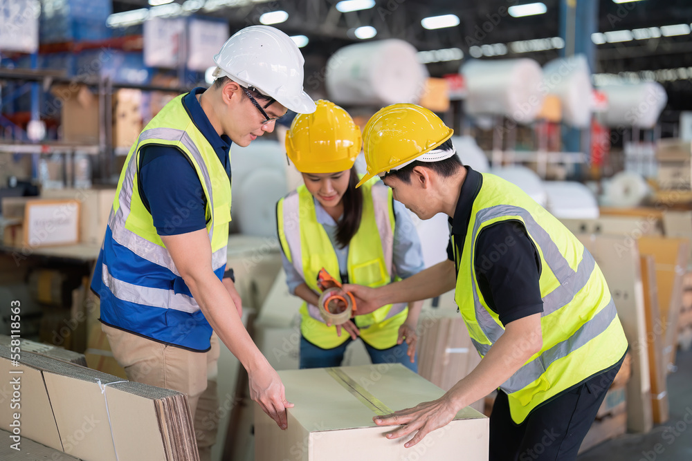 Staff in large storage warehouse together packing goods and carry carton box on pallet Staff in large storage warehouse together packing goods and carry carton box on pallet