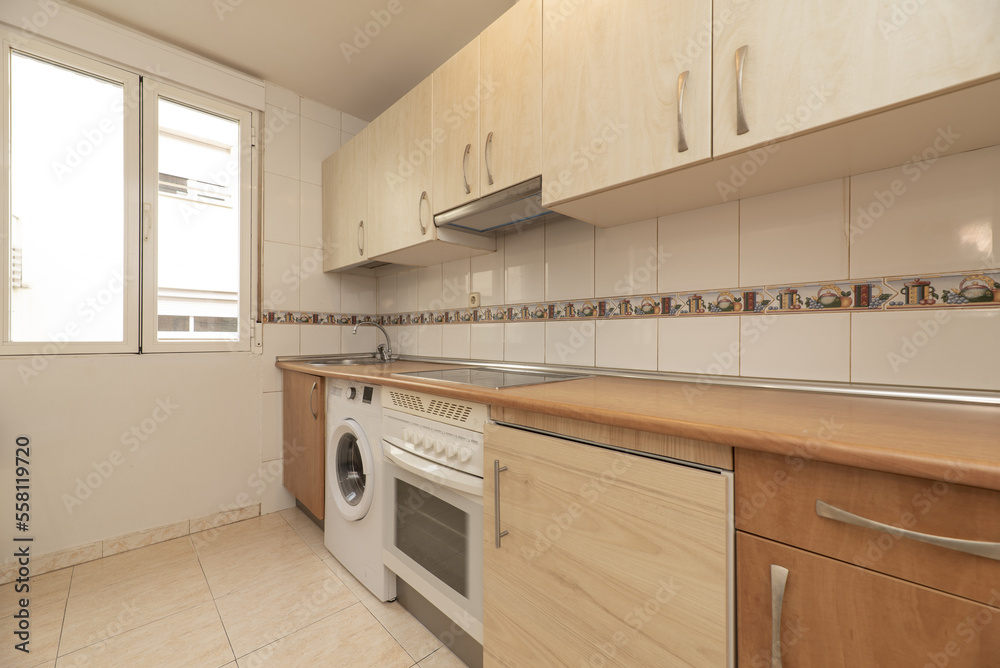 Fototapeta premium Kitchen Equipped with wooden cabinets of one color and the bases and countertop of another to match the stoneware floor