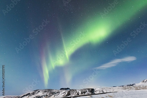 the northern lights over mountain tops in iceland 