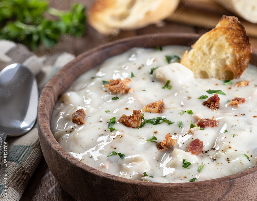 New England clam chowder with bacon, parsley and toasted bread New England clam chowder with bacon, parsley and toasted bread