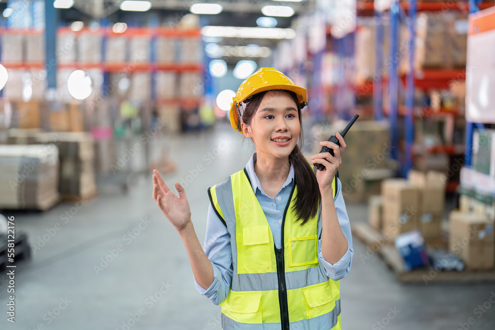 Staff in large storage warehouse use radio walkie talkie explain material storage location to team Staff in large storage warehouse use radio walkie talkie explain material storage location to team