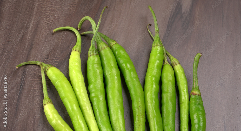 Fresh long Indian green chillies on wooden background. Fresh long Indian green chillies on wooden background.