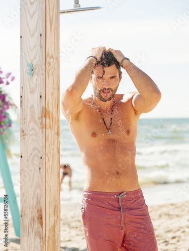 Handsome attractive men showering outdoor on the beach