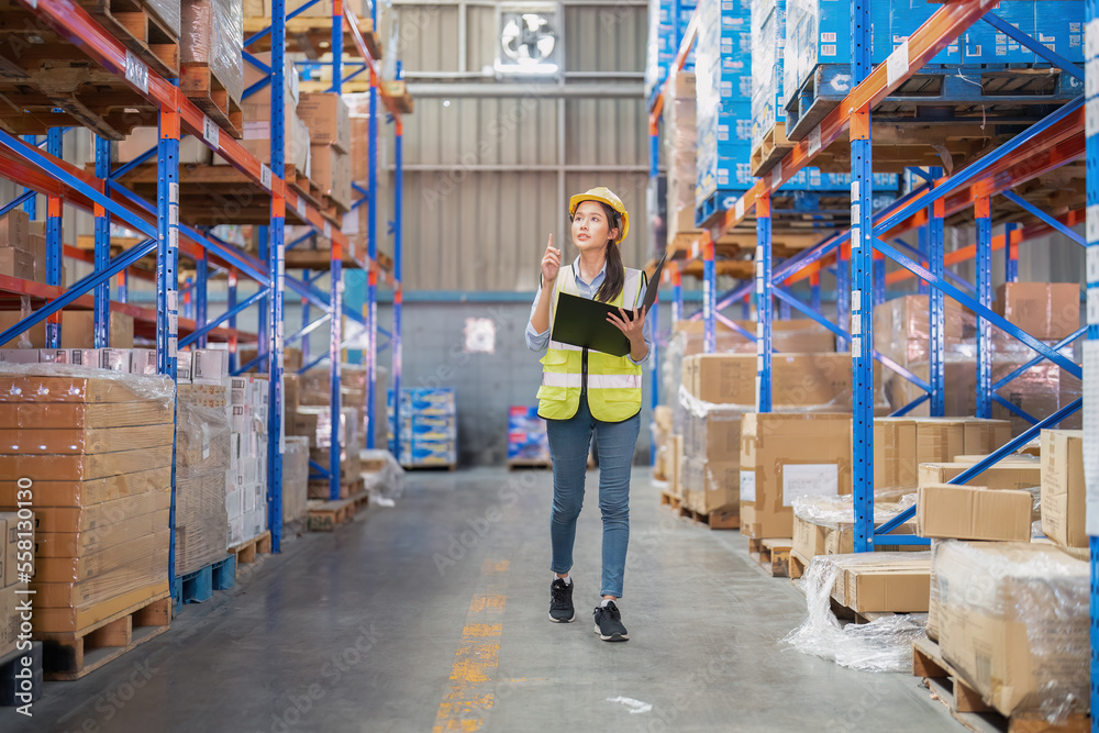 Staff working in large depot storage warehouse hold check list walking check goods on shelf Staff working in large depot storage warehouse hold check list walking check goods on shelf