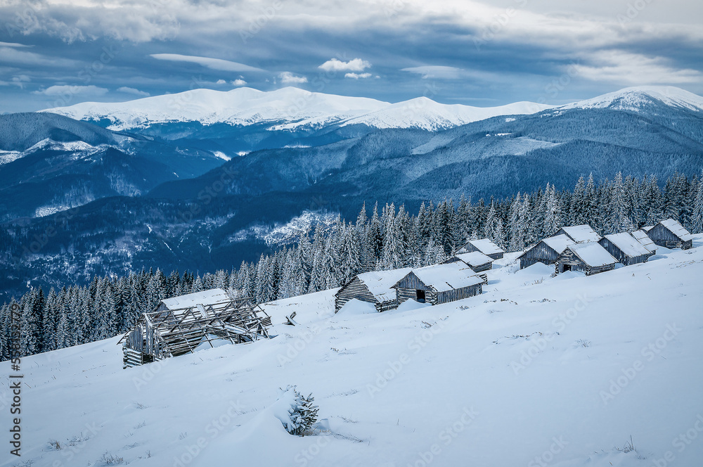 Winter in Carpathian mountains. Abandoned log cabins on the snow