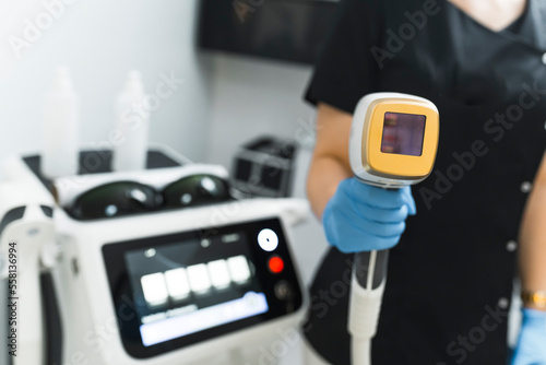 Close-up shot of a laser hair removal device held by a beautician. Blurred background. Beauty concept. High quality photo