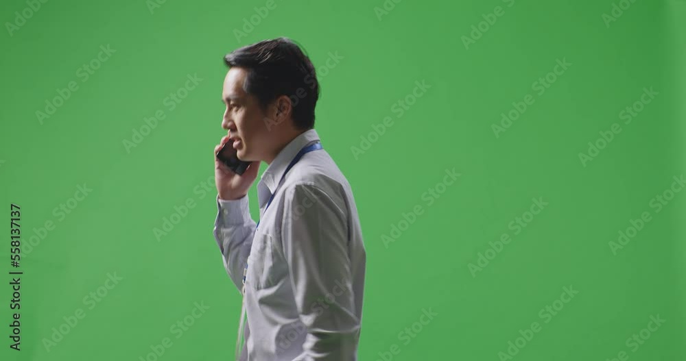 Side View Of Asian Business Man Talking On Mobile Phone While Walking On Green Screen In The Studio
Side View Of Asian Business Man Talking On Mobile Phone While Walking On Green Screen In The Studio