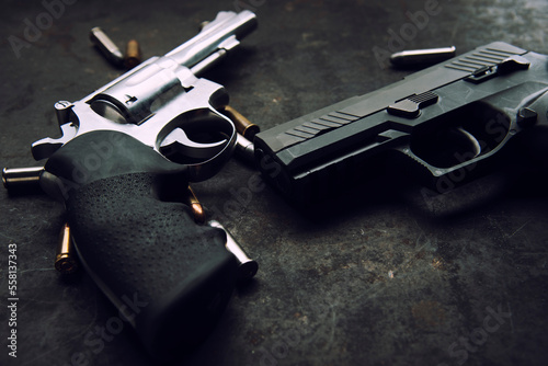 handgun and bullets, gun lies on a dark texture background close-up photo