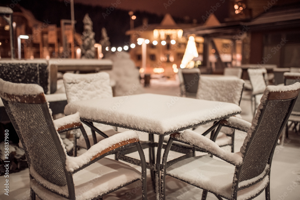 snow covered table and chairs in garden cafe