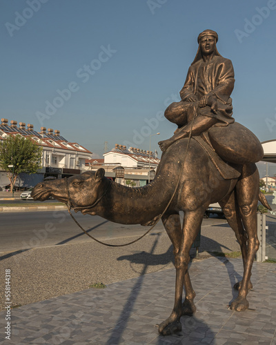 Evrenseki Turkey October 4, 2018: A series of images. Urban sculpture of a camel. Part of the composition "Caravan". It is covered with bronze paint. Entertainment for vacationers at a Turkish resort