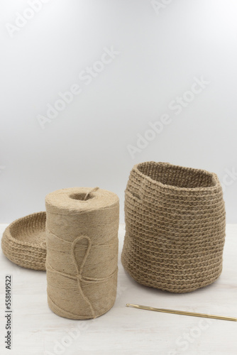 Jute knitted bag and jute babina yarn on a white wooden table