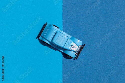 Top view of a blue retro toy car on a blue background.