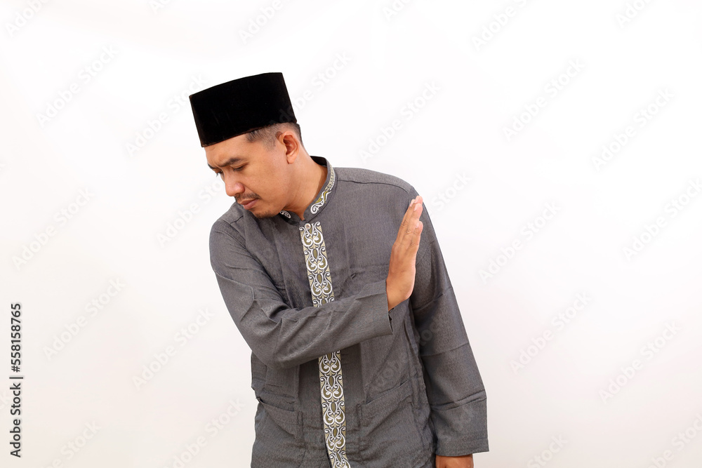 Asian muslim man standing with denial gesture. Isolated on white background Asian muslim man standing with denial gesture. Isolated on white background