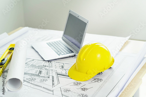 Yellow helmets and tablet computers on table in office center. Engineer team to start new construction project plan. Contractor concept. Collaboration project meeting.