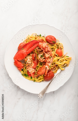 Lobster linguine pasta on the white marble table. Delicatessen, rare seafood pasta recipe. Sardinia, Sicilian, Neapolitan cuisine. Italian and French food. Top view