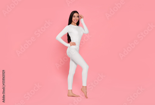 Woman in warm thermal underwear on pink background. Space for text