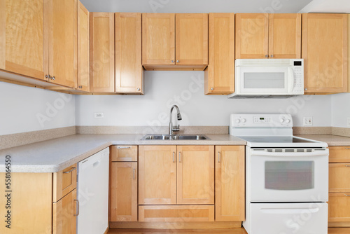 Builder Grade Kitchen with Oak Shaker Cabinets and White Appliances. Basic Kitchen in rental apartment.