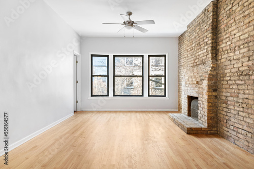 Clean and Bright Vacant Room. Vintage room with antique radiator and brick surround fireplace. Empty room for virtual staging with natural light.
