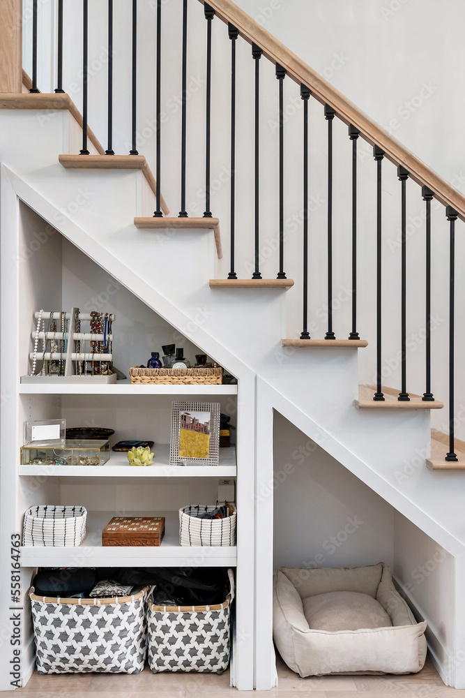 Modern Staircase with Open Storage Underneath. Aesthetic organization in small spaces. Metal stair railing with wooden bannister. - obrazy, fototapety, plakaty 