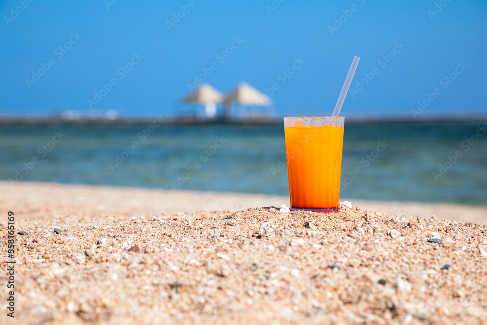 Beautiful cocktails on the sand near the sea shore. Glasses with summer cocktails. Yellow sand on the beach. Sunny summer day. Beautiful cocktails on the sand near the sea shore. Glasses with summer cocktails. Yellow sand on the beach. Sunny summer day.