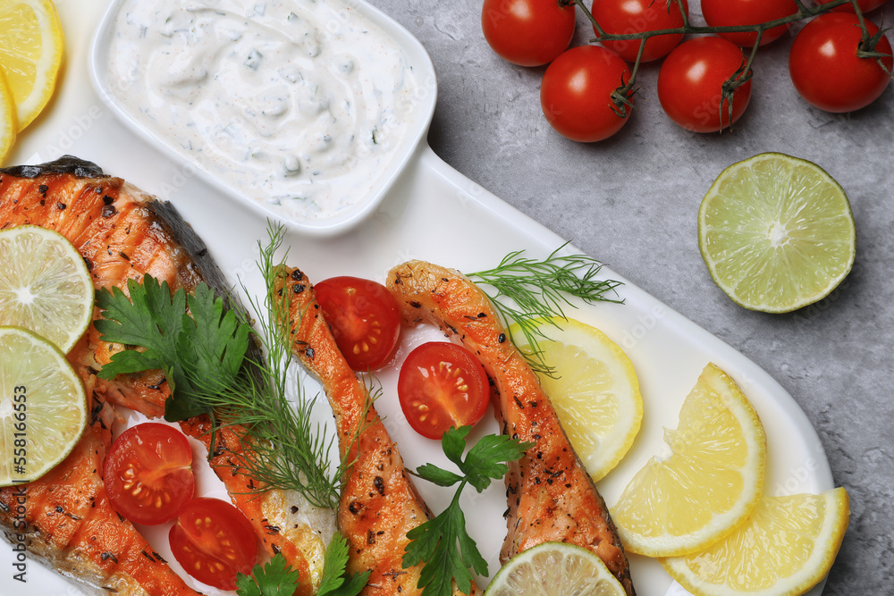 Tasty grilled salmon steaks and ingredients on light grey table, flat lay Tasty grilled salmon steaks and ingredients on light grey table, flat lay