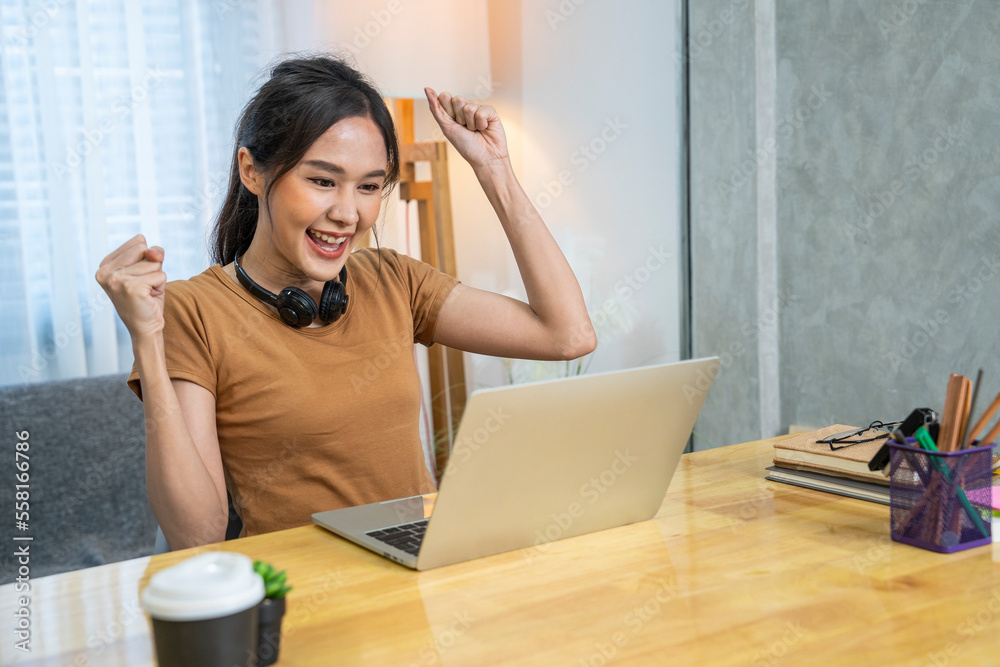 Asian woman working at home wearing headphones typing in homework reports until sleepy and feeling shoulder pain, neck pain, having to stretch arms like office syndrome Asian woman working at home wearing headphones typing in homework reports until sleepy and feeling shoulder pain, neck pain, having to stretch arms like office syndrome