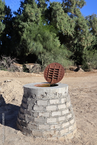 A water well with the rusty hatch open