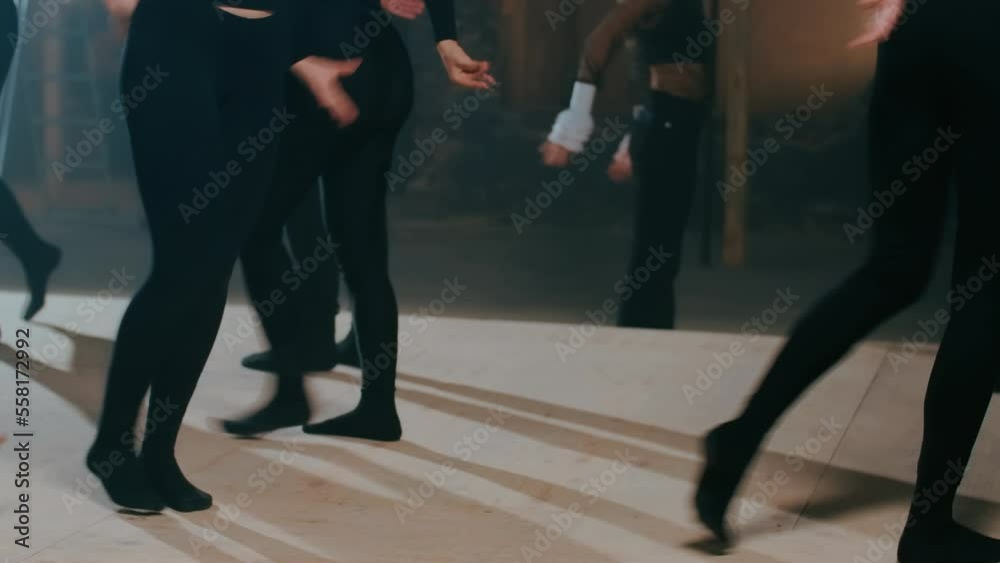 Side view group of unrecognizable talented men and women squatting in lunges with stage director talking showing movement. Professional Caucasian actors and actresses rehearsing in theater Side view group of unrecognizable talented men and women squatting in lunges with stage director talking showing movement. Professional Caucasian actors and actresses rehearsing in theater