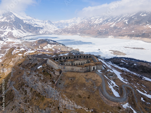 Aerial view of ancient fort ruins in the mountains next to frozen lake and dam. Mont Cenis (Moncenisio) photo