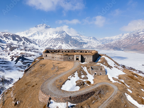 Aerial view of ancient fort ruins in the mountains next to frozen lake and dam. Mont Cenis (Moncenisio) photo