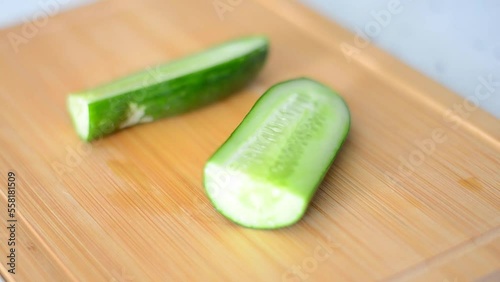 half cucumber,  close up video of the moment when a cucumber cut in half is cut in half lengthwise with a knife