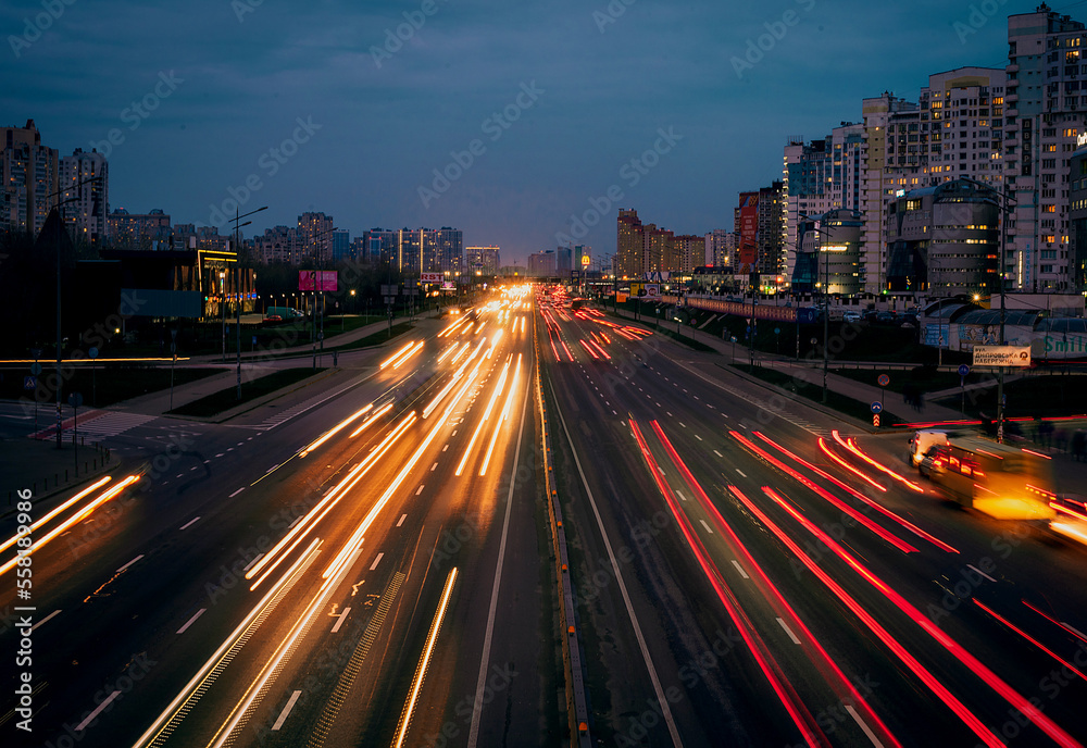 traffic shot from above over a busy road showing streaking trails of light of blurred cars 