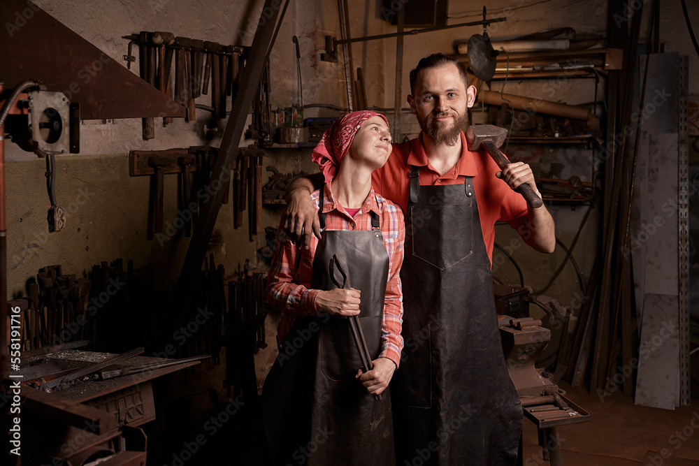 blacksmiths couple with tools in smithy portrait
