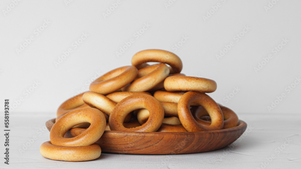 Plate with tasty dry bagels (sushki) on white textured table Plate with tasty dry bagels (sushki) on white textured table