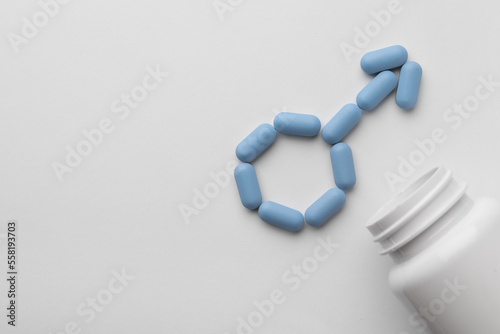 Male sign made of pills and medical bottle on white background, top view with space for text. Potency problem