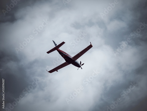 A single-engine turboprop airplane flaying against blue cloudy sky.