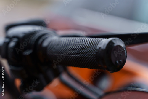 Black throttle on a motorcycle handlebar. Close-up.